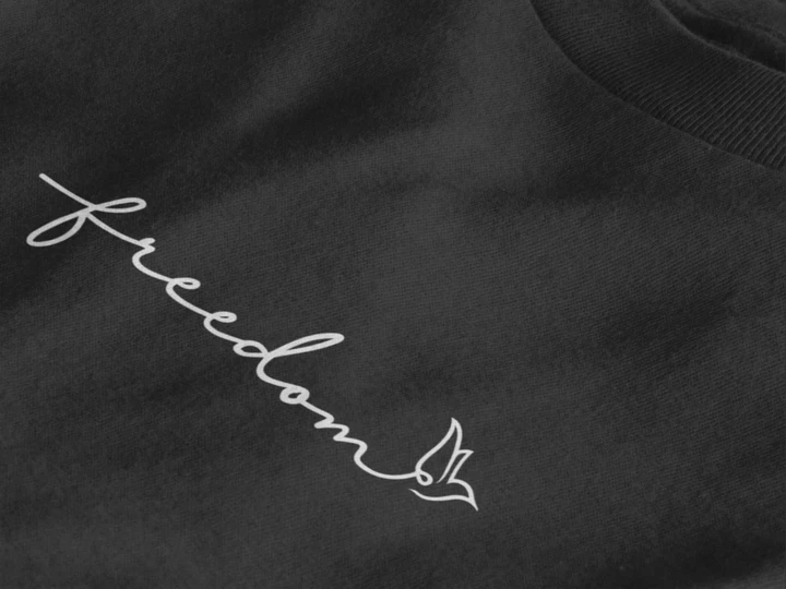 Close-up of a jet black t-shirt with a white cursive script reading 'freedom' and a small bird outline at the end.