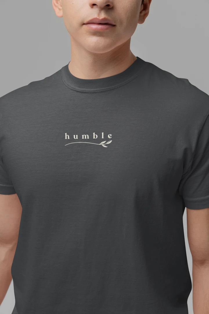 A close-up of a person wearing a Graphite t-shirt with a white 'humble' graphic printed on the chest.