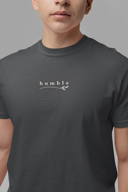 A close-up of a person wearing a Graphite t-shirt with a white 'humble' graphic printed on the chest.