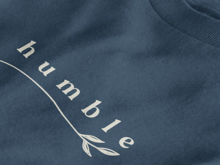 Close-up of a midnight navy crewneck t-shirt featuring a black graphic print that reads 'humble' in a stylized font with a leaf motif.