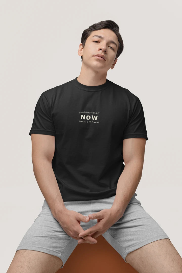A man wearing a Jet Black short-sleeve t-shirt with a white 'FOCUS' logo on the chest, paired with light gray shorts, sitting against a light gray background.