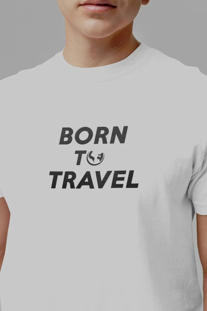 A close-up of a person wearing a Pure White short-sleeve t-shirt with the text 'BORN TO TRAVEL' printed in black on the chest.
