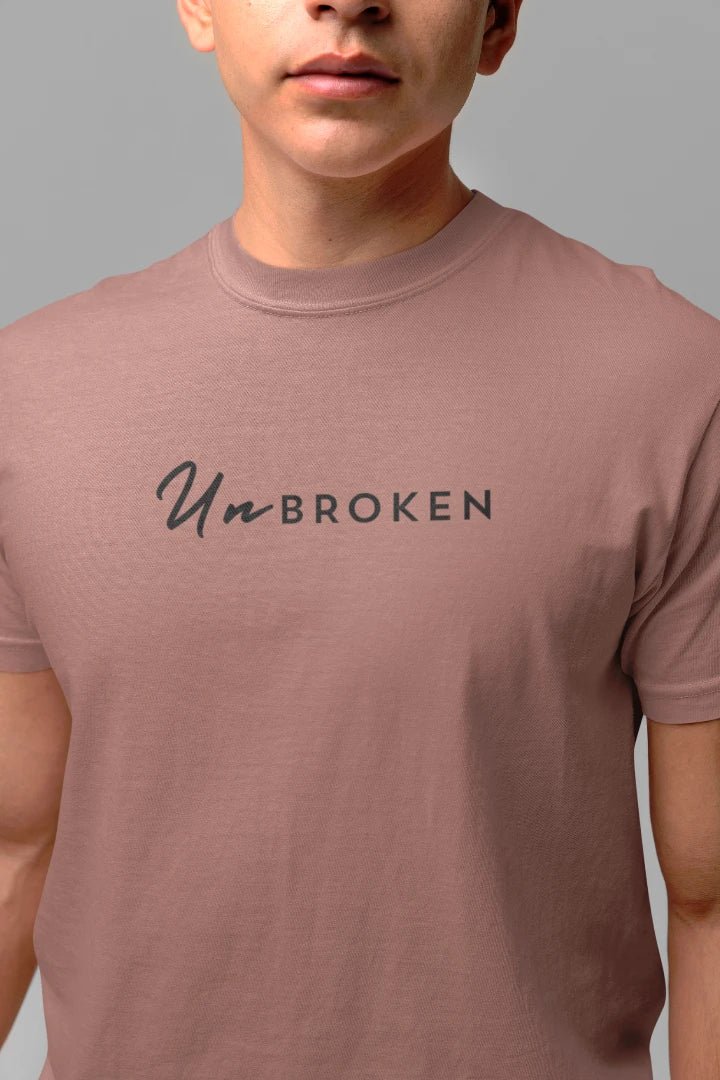 A close-up of a person wearing a mushroom t-shirt with the text 'UnBROKEN' printed in black across the chest.