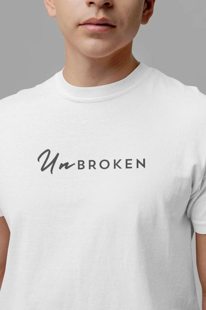 A close-up of a person wearing a white crew-neck t-shirt with the text 'UnBROKEN' printed across the chest in black.